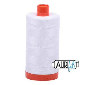 white aurifil thread on an orange spool size large