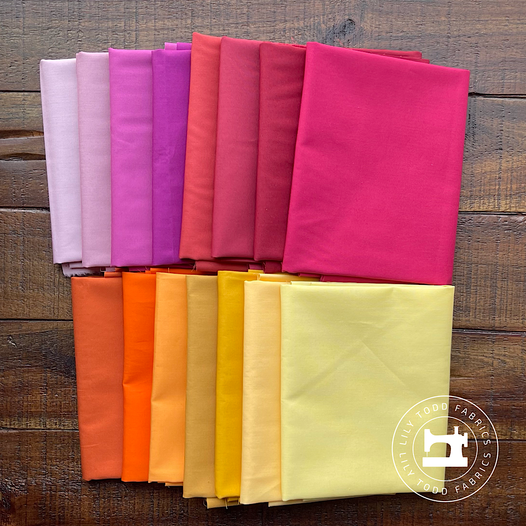 red, orange, yellow, and purple solid fabrics in a bundle that echo sunset colors.